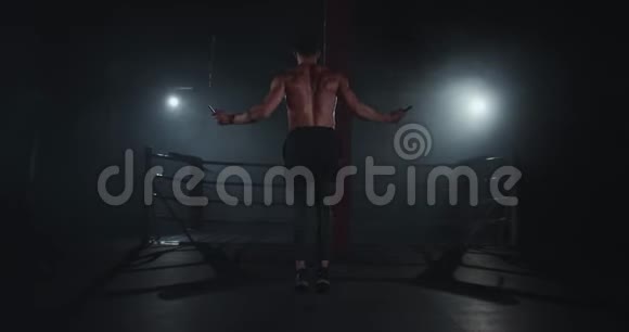 健美男子在黑暗而现代的交叉健身课上用力地在绳子上跳跃视频的预览图