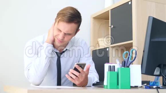 在电脑上工作时脖子疼的年轻人4k慢动作视频的预览图