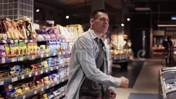 超市里的男人用购物车跳舞在空食品店积极跳舞视频的预览图