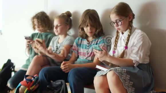 一群青少年坐在学校走廊里拍一张集体自拍孩子和小玩意视频的预览图
