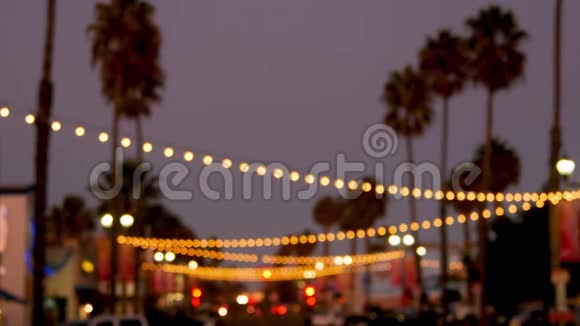装饰凝视花环灯光棕榈树剪影夜空背景模糊装饰着灯的街道视频的预览图