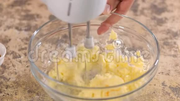 把糖和黄油混合在玻璃碗里在碗里搅拌原料特写镜头视频的预览图