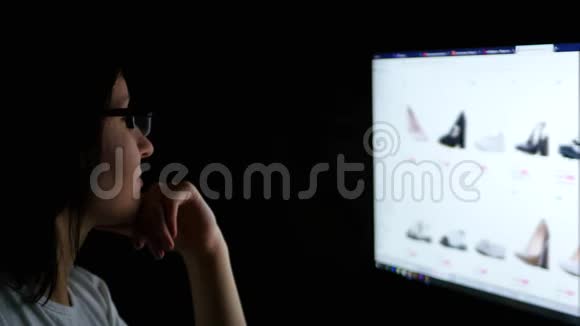 那个女孩晚上坐在电脑前在一家网上商店购物网上购物视频的预览图