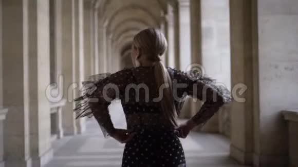 站在历史建筑附近时一位年轻女子拉起裙子的后景行动年轻漂亮的女人视频的预览图