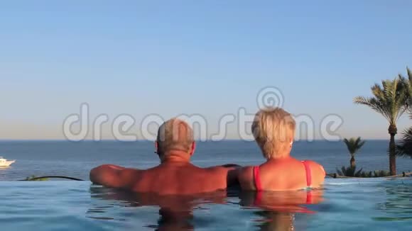 美丽的年轻夫妇在游泳池的度假胜地休息视频的预览图