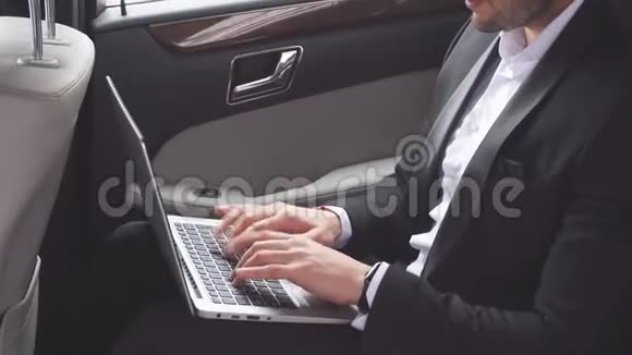 坐在豪华轿车里手提电脑很忙视频的预览图