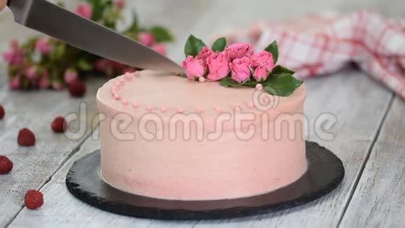 女人切一个用玫瑰装饰的漂亮蛋糕甜食视频的预览图