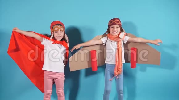 在玩具飞机上穿着蓝色背景斗篷的孩子们开心的录像视频的预览图