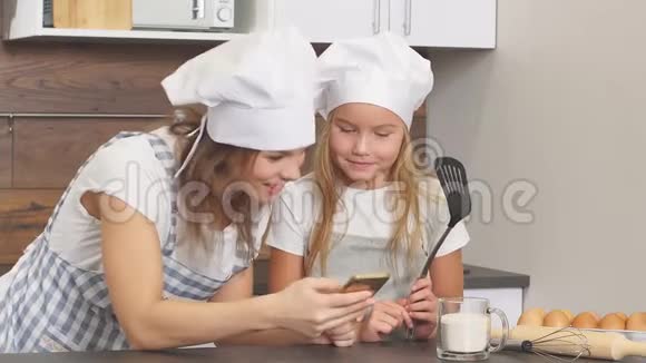 美丽的母女俩用爱看着对方准备在厨房里烤视频的预览图