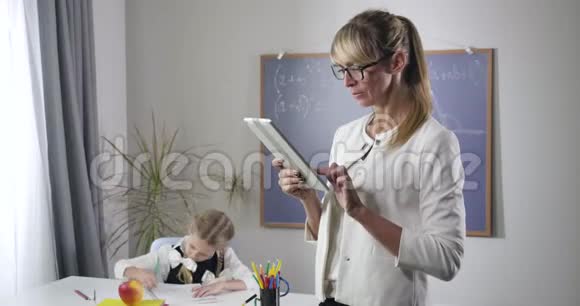 一幅聪明的中年白种女人看着镜头戴着雅致的眼镜面带微笑的照片初等的视频的预览图