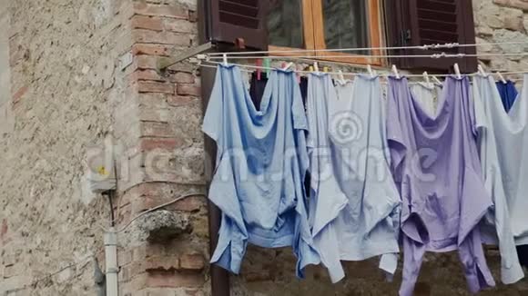 洗好的衬衫在打开的窗户下用绳子擦干传统的洗衣方式视频的预览图