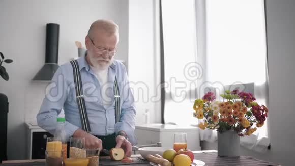 有魅力的老爷爷戴着眼镜留着胡子照顾他的健康准备了一顿健康的早餐视频的预览图