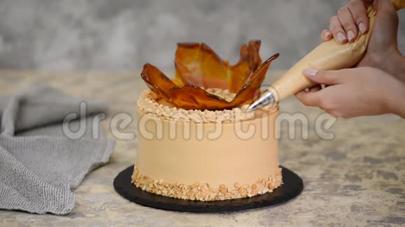 把女人用焦糖奶油装饰蛋糕视频的预览图