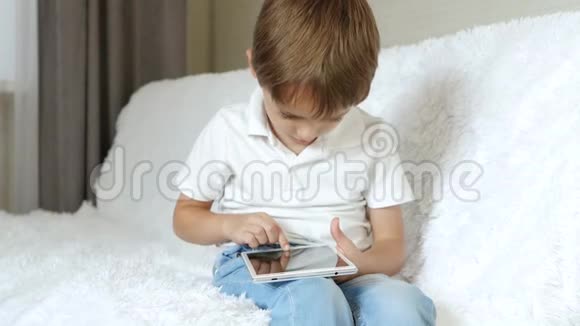 这个男孩热情地使用平板电脑上的应用程序视频的预览图