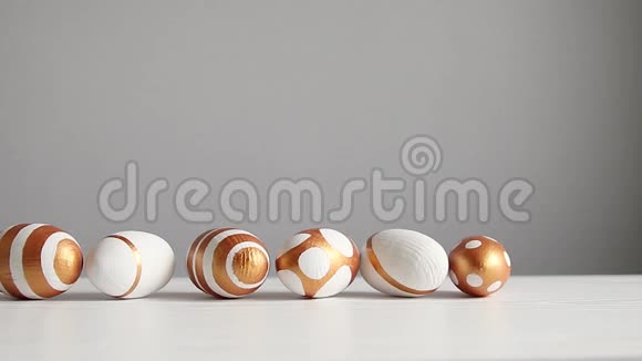 白色桌子上的金色彩蛋装饰视频的预览图