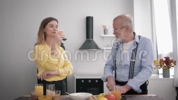家庭关系快乐的小狗老人在厨房准备一份美味的早餐搭配健康的产品混合在一起视频的预览图