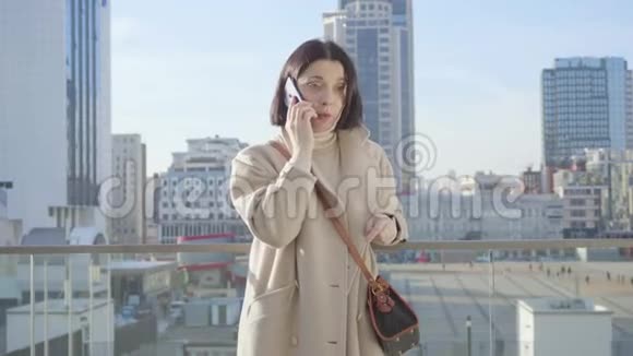 中锋成功的高加索女人在电话里交谈年轻的黑发女士站在城市街道上生活方式视频的预览图
