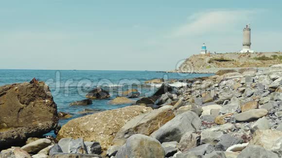 海上海岸线海浪撞击石头灯塔在背景上视频的预览图