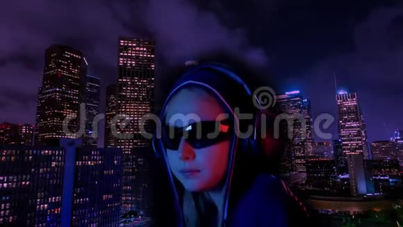 少女戴头罩和黑色太阳镜听耳机音乐霓虹灯城市背景少女口香糖视频的预览图