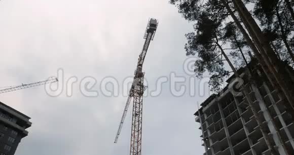 用起重机建造摩天大楼的过程高吊车在有房子的建筑工地施工高层住宅视频的预览图