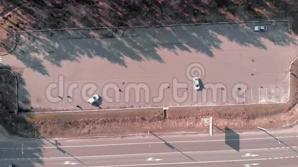 无人机绕空废弃汽车停车俯视图白色汽车在停车场开车和停车专业司机教授视频的预览图