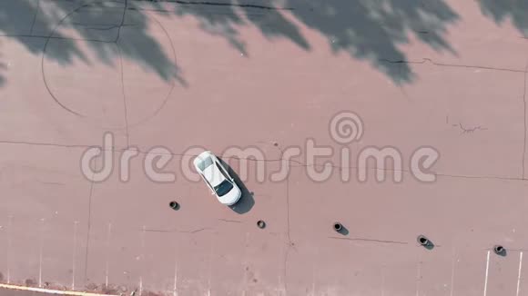 司机练习驾驶汽车在废弃停车场空中无人机顶视图汽车在废弃的停车场视频的预览图