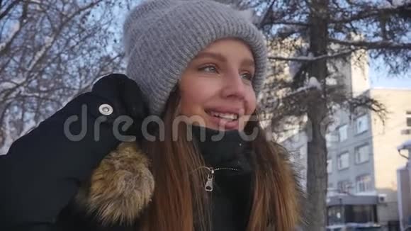 年轻漂亮的女人穿着热情的衣服在一个城市街道的背景下冬季日落慢动作视频的预览图
