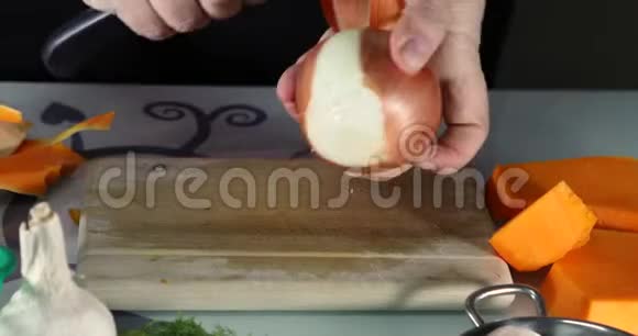女人在厨房的木板上剥洋葱女性手准备奶油汤配南瓜和洋葱健康饮食视频的预览图