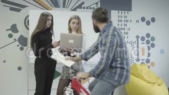 两个漂亮的女人站在一起在办公室里交流骑着自行车的大胡子来找他们给他们送文件视频的预览图