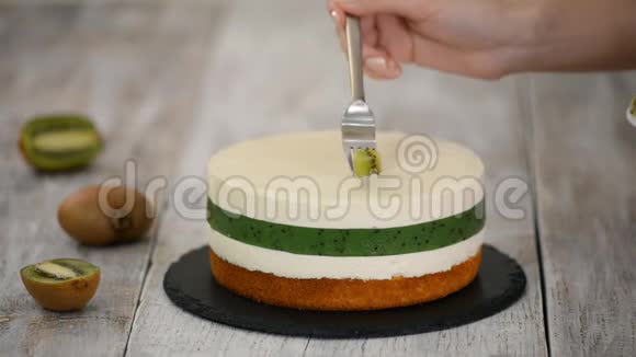 厨师用新鲜的猕猴桃装饰蛋糕自制摩丝蛋糕与猕猴桃视频的预览图