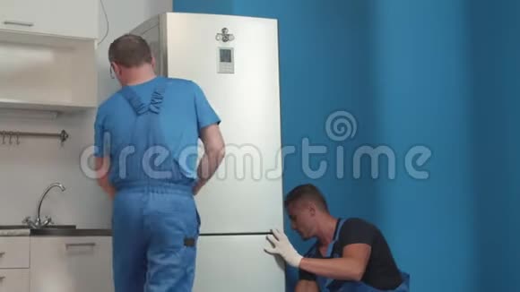 穿制服的男人拿冰箱视频的预览图