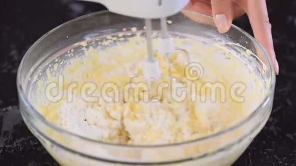 女性手用搅拌机搅拌面团做蛋糕视频的预览图