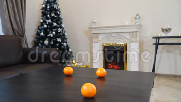 新年和圣诞节准备女人的手把满是成熟橘子的玻璃花瓶放在黑桌上新年树视频的预览图