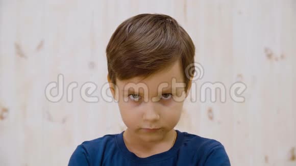 肖像严肃的男孩在演播室的灯光背景上寻找相机近脸小男孩摆姿势拍照视频的预览图
