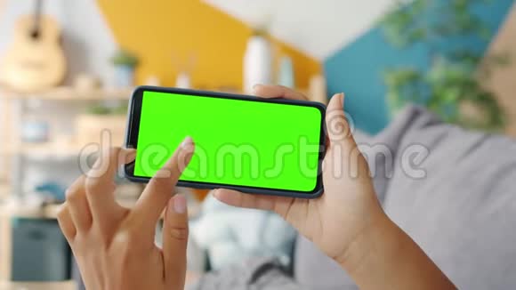 慢动作女孩的手接触绿色垂直智能手机屏幕室内视频的预览图