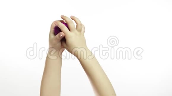 孩子的手在白色背景上玩奇怪的紫色黏液抗压力视频的预览图