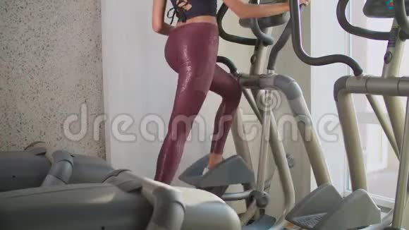 健身妇女在健身房锻炼椭圆健身教练视频的预览图