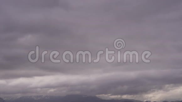 白雪皑皑的山峰上方的雨云缓缓移动视频的预览图
