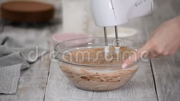 厨师在奶油中加入糖粉然后搅拌做巧克力奶油做蛋糕视频的预览图