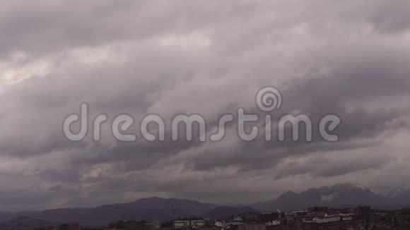白雪皑皑的山峰间的雨云正向城市逼近视频的预览图