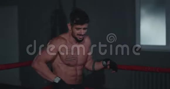 一个身材健美的人在一个黑暗的交叉健身课上进行了激烈的拳击训练视频的预览图