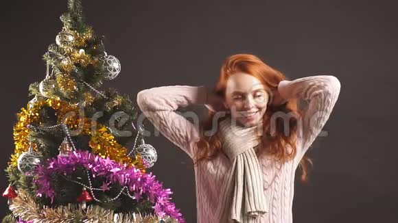 红发女孩在黑底画室圣诞树附近顺利跳舞的肖像视频的预览图