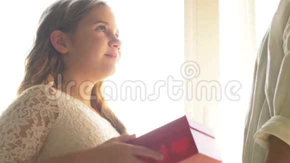 小可爱的女孩微笑着送给快乐的妈妈礼物盒祝贺庆祝母亲节视频的预览图