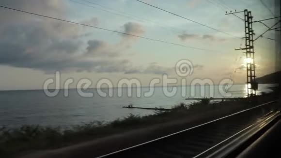 日落浪漫的天空越过大海的风景从火车的窗口观看旅行旅行和度假视频的预览图