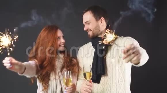 一对夫妇在黑色背景上戴着香槟杯和火花视频的预览图