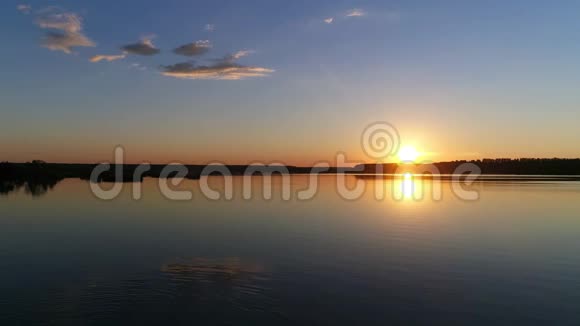 日落在清澈的夏日夜晚在湖泊或河流无人机足视频的预览图
