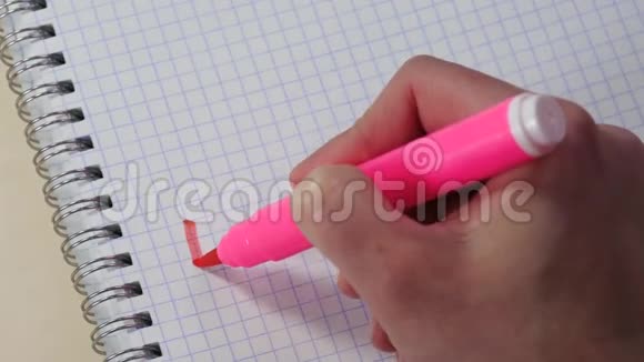 一个女人的手在记事本上用粉红色的记号笔写着我爱你这个词视频的预览图