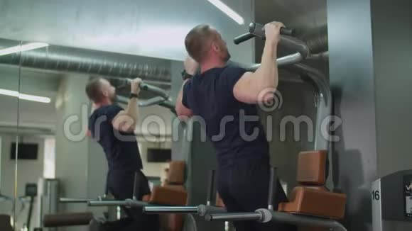 肌肉男在健身俱乐部做拉力赛视频的预览图