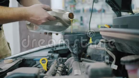 汽车维修技工向汽车发动机注入新的油润滑剂注入新的清洁合成油视频的预览图