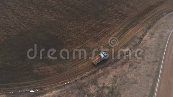 一辆空自卸卡车沿着土路行驶的鸟瞰图建筑工作和处置的概念视频的预览图